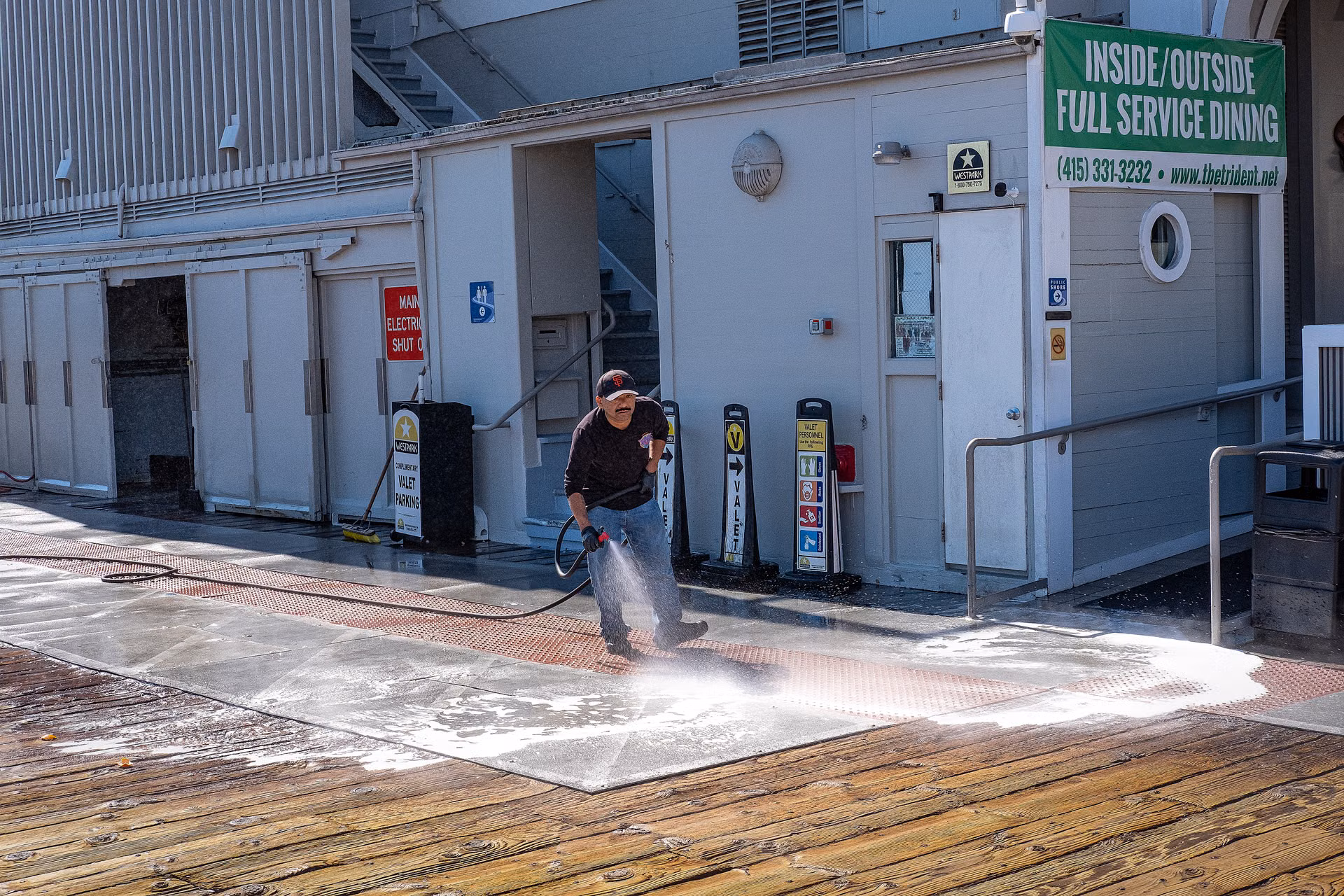 Boardwalk being pressure washed, half clean and half weathered