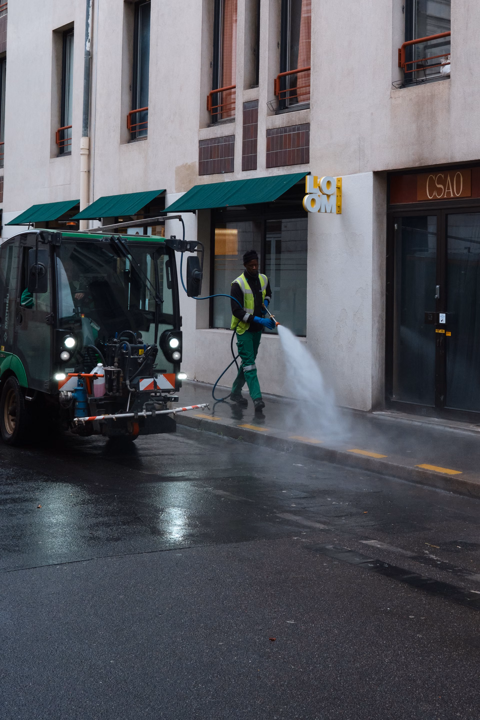 Worker pressure washing a commercial sidewalk