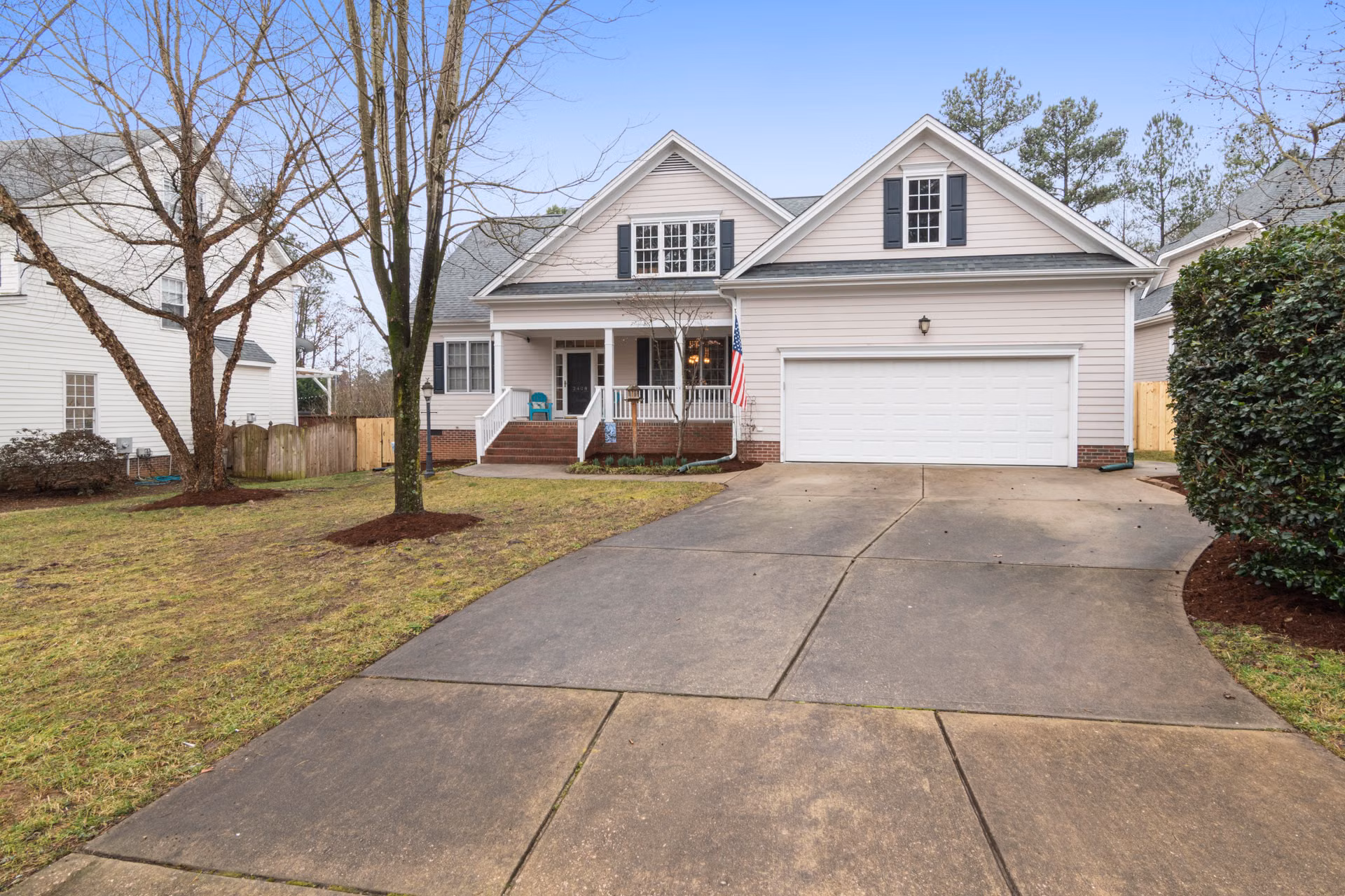 Home with a long, freshly cleaned white concrete driveway